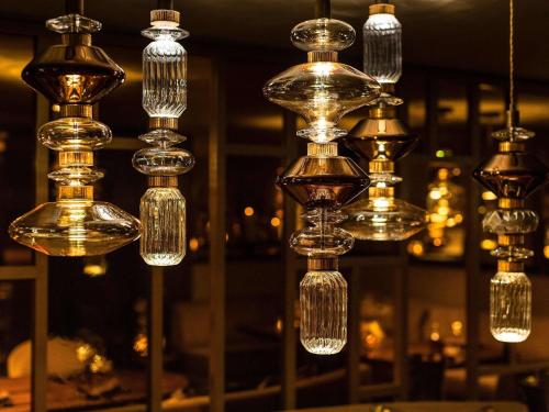 a group of glass chandeliers hanging from a ceiling at Fairmont Hotel Vier Jahreszeiten in Hamburg