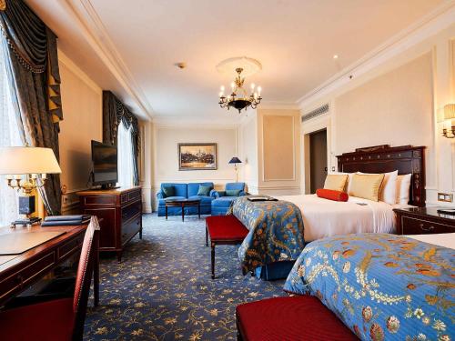 a hotel room with two beds and a desk at Fairmont Grand Hotel Kyiv in Kyiv