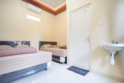 Ένα ή περισσότερα κρεβάτια σε δωμάτιο στο Omah Ati Guesthouse Syariah