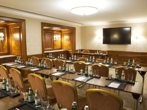 a conference room with tables and chairs and a television at Fairmont Grand Hotel Kyiv in Kyiv