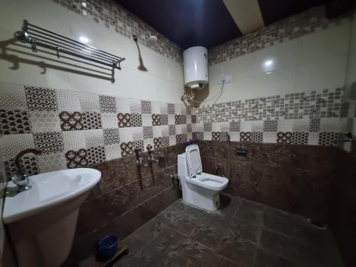 a bathroom with a toilet and a sink at Shanti cafe and stay in Kasol