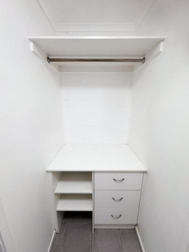 an empty closet with a white desk and shelves at Motel Sunshine Coast in Caloundra