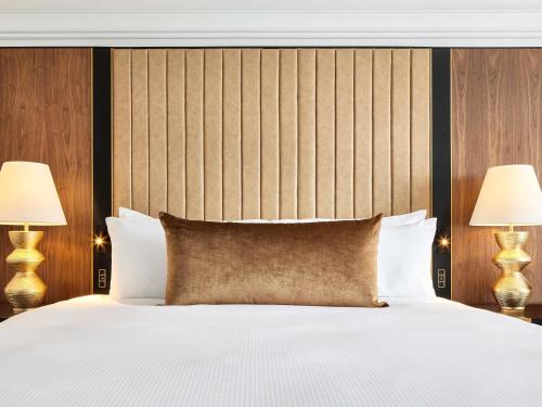 a bedroom with a large white bed with two lamps at The Fairmont Washington DC in Washington, D.C.