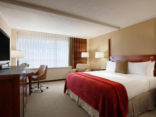 a hotel room with a large bed and a desk at Fairmont Winnipeg in Winnipeg