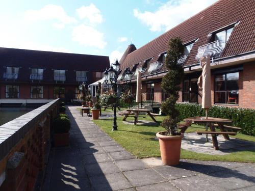 a row of picnic tables in front of a building at Lakeside International Hotel in Camberley