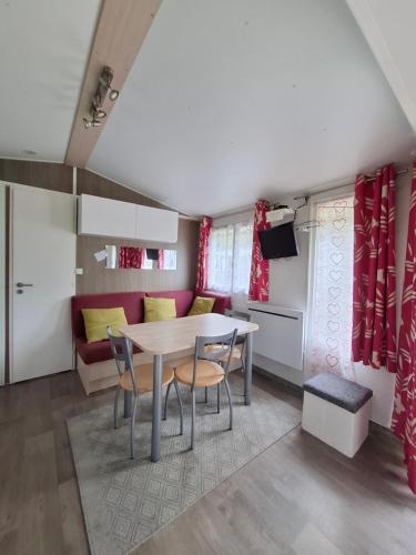a kitchen and living room with a table and chairs at Mobil home 4 personnes au pied du Grand Massif à Samoëns in Samoëns