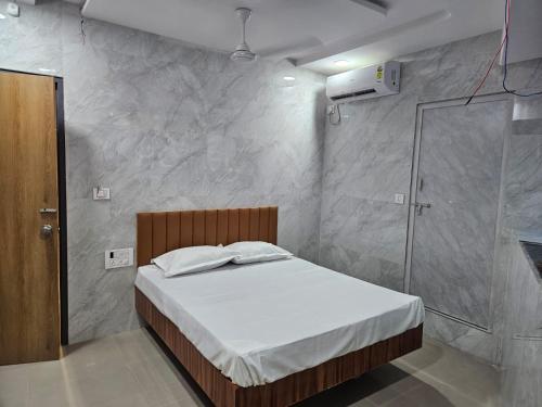 a bedroom with a bed and a glass shower at Hotel OLOTUS in Surat