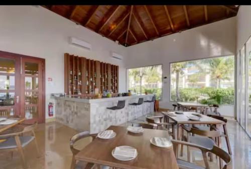 a restaurant with wooden tables and chairs and windows at La Amada Residences. Best Stay in Cancún