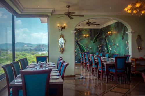 a dining room with tables and chairs and a painting at Jhadol Vijay Vilas Near Lake Pichola in Udaipur