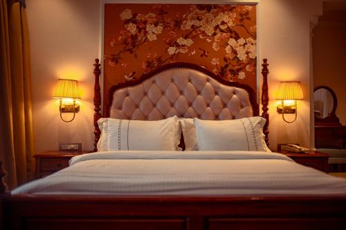 a bedroom with a large bed with two lamps at Jhadol Vijay Vilas Near Lake Pichola in Udaipur