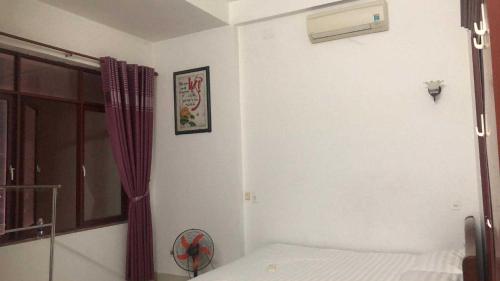 a bedroom with a bed and a window and a fan at Nhà nghỉ hảo hảo in Da Nang