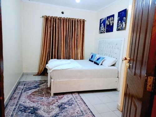 a small bedroom with a bed and a window at Blissful abode in Kisumu