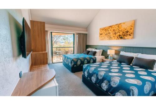 a hotel room with two beds and a television at Discovery Resorts - Kings Canyon in Kings Canyon
