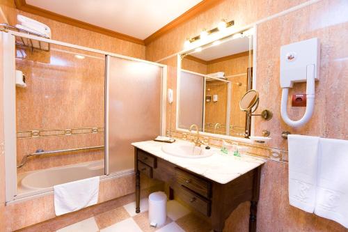 a bathroom with a sink and a shower and a mirror at Hotel San Agustin Beach Club in San Agustin