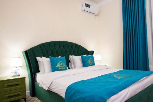 a bed with a green headboard in a room at Air Plaza in Samarkand