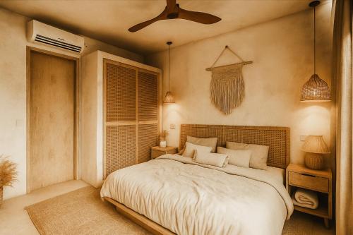 a bedroom with a bed and a ceiling fan at Kavo Maison Surf & Yoga Camp in Munggu