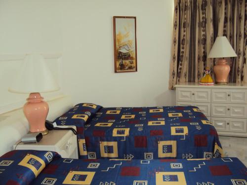 a bedroom with a bed with a blue and yellow comforter at Hotel Acapulco Malibu in Acapulco