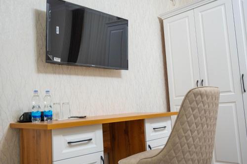a desk with a television and two bottles of water on it at Air Plaza in Samarkand