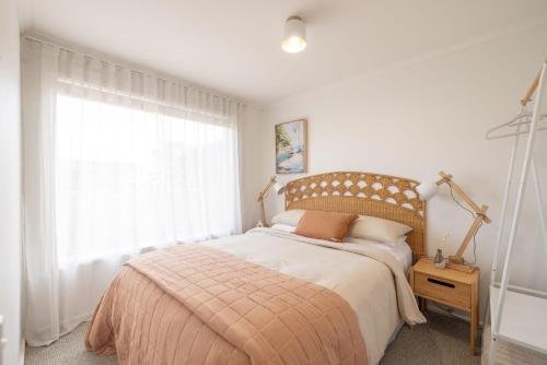 a bedroom with a bed and a large window at PI Hot Springs Retreat1 in Surf Beach