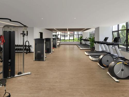 a gym with a row of treadmills and machines at Swissotel Beijing Hong Kong Macau Center - 1 min to subway in Beijing