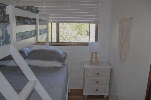 a bedroom with a bunk bed and a window at Doc's Place at Crescent Head in Crescent Head