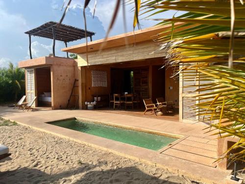 a house with a swimming pool on a beach at Mazul Puerto Escondido in Tlachicón