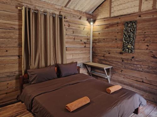 une chambre avec un lit dans une cabane en rondins dans l'établissement Nirvana Archipel Resort, à Vang Vieng