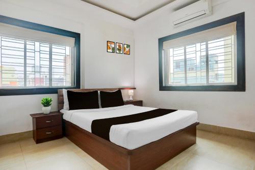 a bedroom with a large bed and two windows at Super Collection O Biswa Bangla Kolkata Formerly Dream Palace in Kolkata