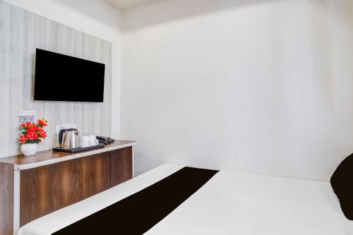 een hotelkamer met een bed en een tv bij Super COLLECTION O SIXMILE GUWAHATI FORMERLY HOTEL GANGOTRI in Guwahati