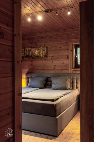 a bedroom with a bed in a wooden wall at Holzblockhaus, Eifel in Oberkail