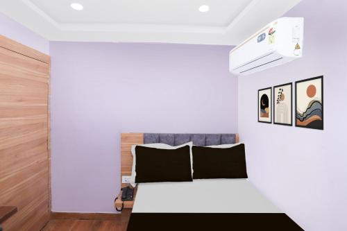 a white bedroom with a bed with black pillows at Super Townhouse Rauniyar City Centre Ratu Road in Rānchī