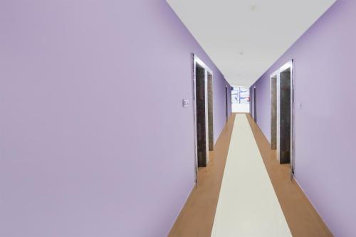 a long hallway with blue walls and wooden floors at Super Townhouse Rauniyar City Centre Ratu Road in Rānchī