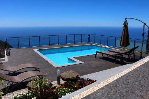 a swimming pool with a view of the ocean at Casa da Caixeira in Arco da Calheta