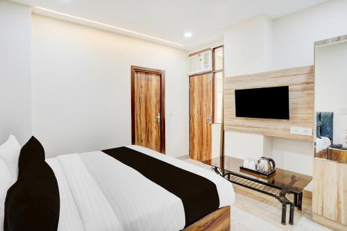 a bedroom with a bed and a flat screen tv at Super Collection O Karkardooma Court Metro Station Formerly Hotel Lotus in New Delhi