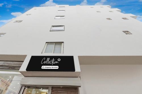 a white building with a black sign on it at Super Collection O Karkardooma Court Metro Station Formerly Hotel Lotus in New Delhi