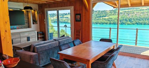 a dining room with a table and a view of a lake at SEEBLICK romantic chalet spa lake view in Paladru