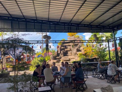 a group of people sitting at tables in front of a fountain at Tulip Hotel in Louang Namtha