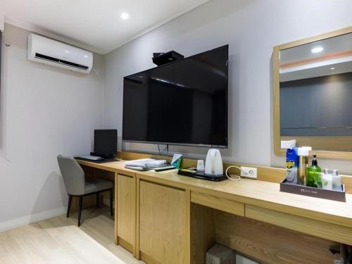 a room with a desk with a large flat screen tv at Hotel Primo Daejeon in Daejeon