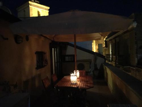 a table with an umbrella on a street at night at Guest House Dimora Fiorita in Serracapriola
