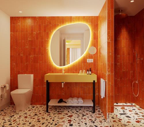 a bathroom with a sink and a toilet and a mirror at Riviera Hotel Menorca in Ciutadella
