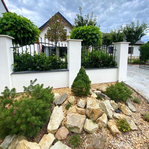 a house with a fence and a rock garden at Deer Apartment in Lipí