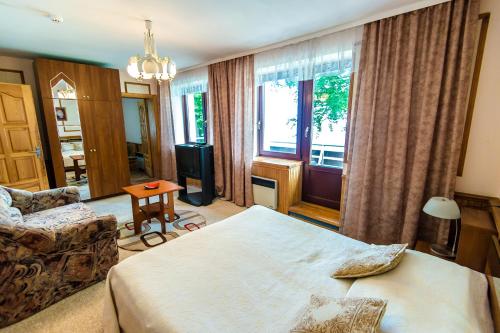 a bedroom with a bed and a couch and a window at Palva in Klaipėda