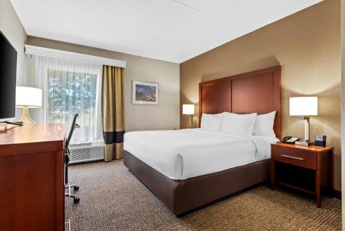 a hotel room with a large bed and a desk at Comfort Inn Chambersburg North in Chambersburg