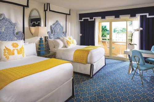 Eau Palm Beach Resort & Spa في بالم بيتش: غرفة فندقية بسريرين ومكتب