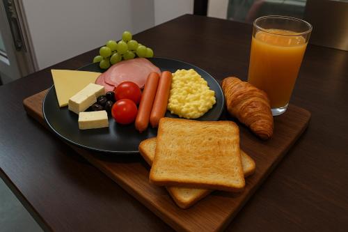 a plate of food with cheese bread and a glass of orange juice at Botev Design Apartments - Walk to Old Town - Pumo Properties in Bucharest