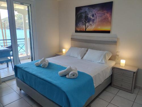 a bedroom with a bed with towels on it at Captain Nick Aparthotel in Mikros Gialos