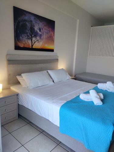 a bedroom with a large bed with towels on it at Captain Nick Aparthotel in Mikros Gialos