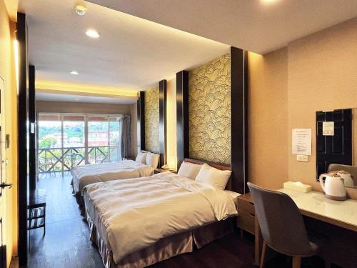 a hotel room with two beds and a desk and a desk at Ci Meng Rou Resort Villa in Dahu