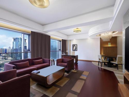 a living room with a couch and a table at Swissôtel Grand Shanghai - Stroll down West Nanjing Road and soak in downtown Shanghai vibrancy in Shanghai