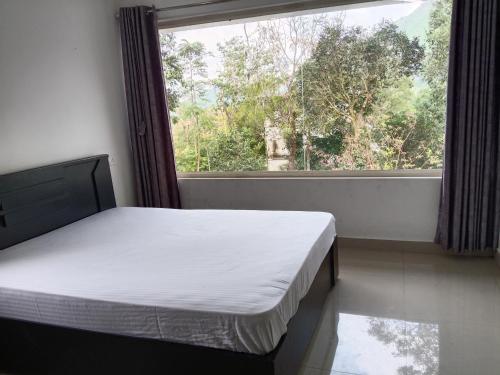 Red Chill Resort في فاغامون: غرفة نوم بها سرير ونافذة كبيرة